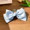 Light blue satin butterfly hair claw clip for women on a rustic wooden background - Blue Satin Bow Cross Style Claw Clip / Blue