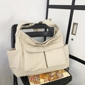 Minimalistische roomwitte canvas schoudertas met grote voorzakken en brede schouderriem - Broken Wit