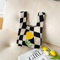 Checkerboard knit tote bag with yellow flower embroidery on a neutral leather couch - Black and White Checkerboard Flower