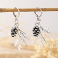 Detailed view of silver pine cone and branch earrings hanging on a rustic wooden twig - Pine Cone and Branch Style (G-045) / Silver