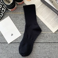 Classic black ribbed cotton crew socks for men paired with stylish casual sneakers - One Size / Black