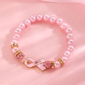 Detail of pink pearl bracelet featuring enamel hope ribbon charm and sparkling crystals - Silver 'HOPE' Pink Ribbon Pearl Bracelet (G-556)