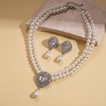 Detail view of double-layer pearl necklace and drop earrings set on a rustic stone base - White (2-Piece Set)