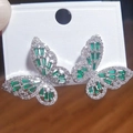 Detail of silver butterfly stud earrings with emerald green rectangular cut zircon - White Gold Green Zirconia