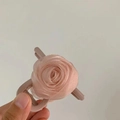Dettaglio macro della molletta per capelli rosa in organza con delicati petali in tessuto - Rosa