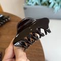 Détail d'une pince à cheveux brillante en résine marron foncé avec des dents solides - Chocolat