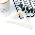 Elegant cream-white triangular hair claw clip with golden spring on aesthetic background - Off White