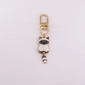 Close-up of a cartoon cat alloy keychain with golden lobster clasp on plain background - Siamese Style Cat