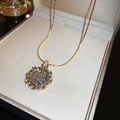 Collana dorata con pendente rotondo e gemme colorate in una scatola per gioielli - Antica Moneta in Pietra Preziosa Colorata Vintage Oro