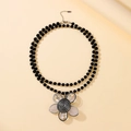 Long beaded sweater necklace featuring double-layer black beads and large floral pendant - Black