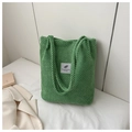 Sac cabas en tricot vert avec texture gaufrée et étiquette carrée sur un lit blanc - Vert