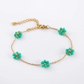 Detail of gold chain bracelet featuring turquoise beaded flowers and lobster clasp - Turquoise