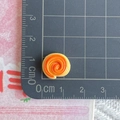Macro detail of 1.2cm mini spiral resin charm measured on a grid mat for DIY crafts - Spiral Torn Bread