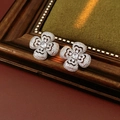 Detailed view of silver clover earrings with sparkling cubic zirconia on a rustic wooden background - Silver Needle Stud Earrings - Silver