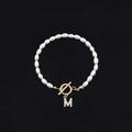 Elegant white oval pearl bracelet featuring a gold OT clasp and a sparkling letter M pendant - Gold Letter M (SL2013)