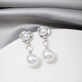 Macro detail of elegant silver earrings with white pearls and sparkling rhinestones - Silver Double Pearl Drop Dangle