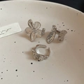 Detailed view of three silver irregular floral and lava style rings on a ceramic plate - Silver Round 3-Piece Set