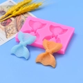 Siliconen vorm met strikjes voor fondant en chocolade op blauwe achtergrond - Dubbele Gat Strik Stijl / Roze