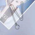 Détail d'un collier chaîne à billes argentée avec grand pendentif anneau en O sur un magazine - Collier chaîne à billes argent avec grand anneau rond