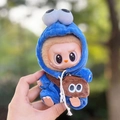 Plush doll in blue monster onesie with big eyes and a brown crossbody bag accessory - Blue Crossbody Bag Sesame Bird Two-piece Set / First And Second Generation Keychains Are Compatible With La Cloth Dolls. Dolls Not Included.