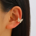 Detail of a golden butterfly ear cuff with shimmering micro-set zircons on the ear cartilage - Paved Butterfly Style (8557) / Gold