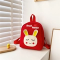 Close-up of red canvas kids backpack with cute white rabbit embroidery and top handle - Red