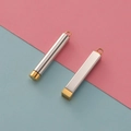 Detail of silver and gold stainless steel cylindrical and square pendant accessories - Cylinder / Gold (Inner) + Steel (Outer)