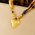 Dettaglio di un ciondolo a cuore dorato con nastro floreale su base beige testurizzata - Stile Cuore Con Trama E Bordo Perlinato (N3635)