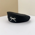 Elegant black beret hat for women featuring a delicate white pearl bow decoration - M (56-58cm) / Black
