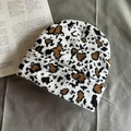 Macro shot of thick leopard print knit beanie with soft vintage texture on grey fabric - One Size / Small Leopard Print