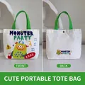 White canvas handbag with green handles featuring a colorful cartoon monster pattern - Cool Cute Monster-White