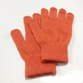 Nahaufnahme hellorangefarbener Strickhandschuhe mit elastischen Rippbündchen für Winter - Orangerot