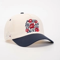 Close-up of embroidered red lips and star details on a beige and navy baseball cap - Cream/Navy Blue