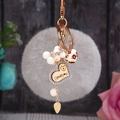 Détail d'un porte-clés pompon gris avec strass et cœur gravé I Love You élégant - Cœur en bois + Pompon gris
