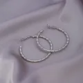 Silver hoop earrings with bamboo texture on a grey silk background with clasp closure - E-033---Platinum