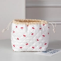 Close-up of quilted drawstring cosmetic bag featuring cute red cherry patterns and textures - White Red Cherry