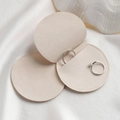Elegant beige microfiber jewelry pouch for rings displayed on silk with a shell - Beige