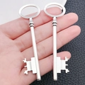 Close-up of vintage silver heart-shaped key pendant held in hand to show size - Long Vintage Key (5872)