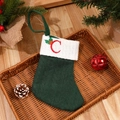 Green knitted Christmas stocking with white cuff and red embroidered letter C detail - Letter C
