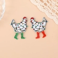 Close-up of festive acrylic white chicken earrings with Christmas hats and glitter boots - Left Green Boot Right Red Boot