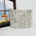 Detail of floral canvas tote bag featuring beige paisley pattern and woven front label - Beige Ethnic Style