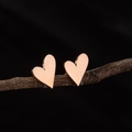 Orecchini a lobo a cuore in oro rosa 18K lucido esposti su un ramo di legno naturale - Oro rosa