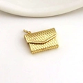 Macro detail of a mini gold-tone envelope bag pendant with textured quilted pattern - Golden Envelope Handbag (06)