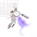Close-up of dreamcatcher keychain with purple feathers and Hamsa hand charm - Purple