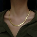 Close-up of minimalist gold snake chain necklace worn by a model in deep green shirt - Gold 5MM 55CM