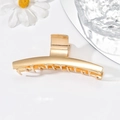 Minimalistische goldene Haarklammer aus Metall mit schlankem Design auf weißem Grund - Große Ein-Wort-Form / Gold