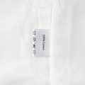 Détail de l'étiquette de lavage 100% coton et de la texture du tissu d'une robe blanche - Blanc (100% Coton)