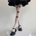 Nahaufnahme weißer Lolita-Strumpfhosen mit Lochmustern und schwarzen Satinschleifen - Weiß Schwarze Schleifen