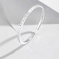 Brazalete plateado ajustable con acabado de textura brillante sobre un fondo blanco puro - Oro Blanco