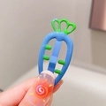 Detailed view of a cute blue carrot hair clip with green leaves held by fingers - Blue
